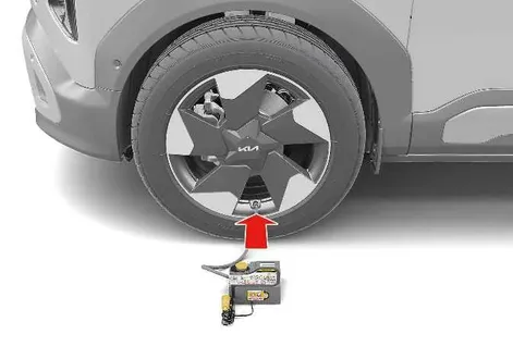 Connecting the compressor hose to the tyre valve during pressure check on a Kia EV2