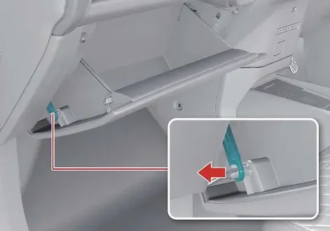 Technician unhooking the glove box damper on the passenger side of a Kia EV2 dashboard