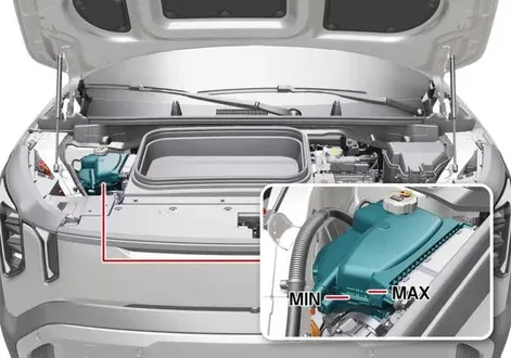 Close-up view of a technician inspecting the translucent coolant expansion reservoir and fluid level lines under the hood of a Kia EV2