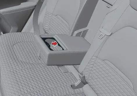 Rear sliding cup holder mechanism fully extended and open for passenger use in the Kia EV2