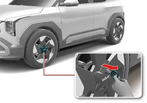 Demonstration of using the specialized remover tool to detach the wheel cover on a Kia EV2 wheel assembly