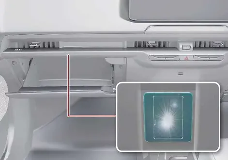 Open passenger glove box compartment illuminated by the interior glove box light in the Kia EV2