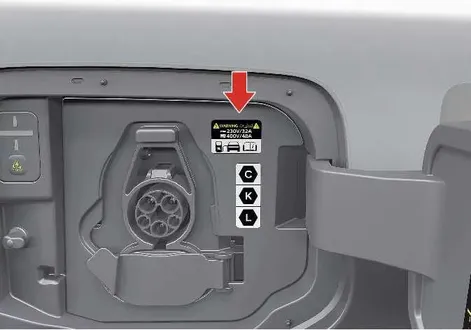 Detailed view of the Kia EV2 vehicle charging inlet compartment showing safety label placement and European standards compliance