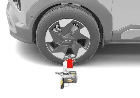Connecting the compressor hose to the punctured tyre valve on a Kia EV2