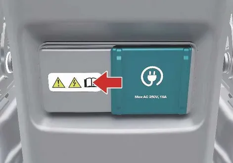 Interior V2L power outlet socket and protective cover panel located inside the cabin of the Kia EV2