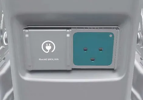 External Vehicle-to-Load adapter connected to the exterior charging port of the Kia EV2