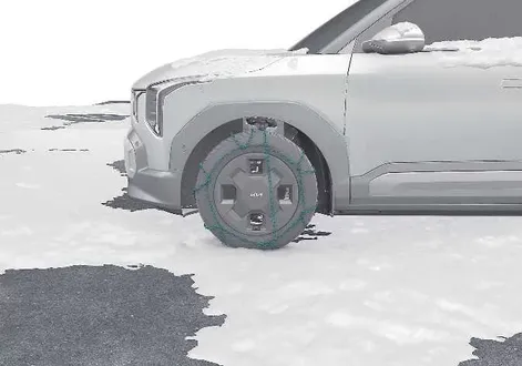 Kia EV2 winter driving guide showing wire type tyre chains mounted on a wheel